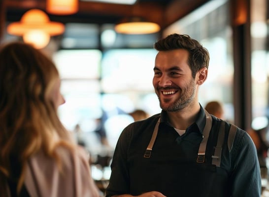 Men and woman guest services talking to guests in front of her, with a smile, in a restaurant-Apr-22-2025-10-45-23-4084-AM